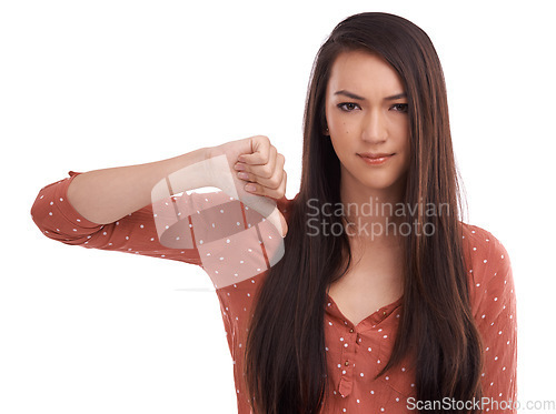 Image of Woman, thumbs down and frowning in frustration, wrong or expression against a white studio background. Portrait of isolated female model pointing thumb down for negative, incorrect or displeased