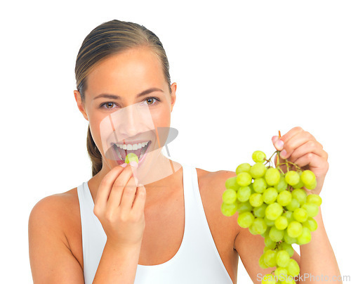 Image of Health, diet and woman with grapes in a studio for a healthy snack, nutrition or craving. Wellness, weightloss and portrait of a young female model eating fruit while isolated by a white background.