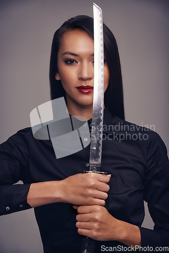 Image of Portrait, ninja and sword with warrior woman in studio on a gray background for martial arts or combat. Training, fantasy and weapon with an asian samurai ready to defend using self discipline