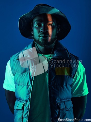 Image of Trendy, casual and portrait of a black man in a studio with a cool, stylish and edgy outfit. Fashion, style and African male model with modern clothes posing while isolated by a blue background.