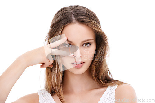 Image of Portrait, hand and eyes with a model woman in studio on a white background with her fingers on her face. Microblading, eyecare and beauty with an attractive young female posing to promote cosmetics