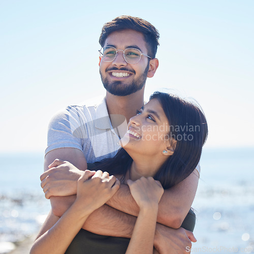 Image of Smile, hug and support with couple at beach, travel and care on summer holiday by ocean, commitment and love outdoor. Young, happy and relationship with romantic date, man and woman embrace on trip