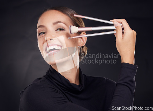 Image of Makeup, brush or portrait of woman in studio with beauty cosmetics or facial foundation products on black background. Makeup artist, smile or happy girl brushes face for luxury skincare grooming