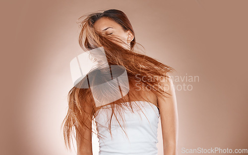 Image of Hair care, beauty and cosmetics of a woman shaking her head on studio background for luxury keratin treatment. Headshot of aesthetic model posing for salon, luxury hairdresser and wellness mockup