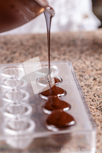 Image of Baker pours chocolate