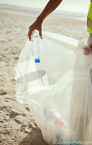 Image of Cleaning, plastic and hands of volunteer at beach for recycle, environment or earth day. Recycling, sustainability and climate change with charity activist and trash bag for pollution or eco friendly