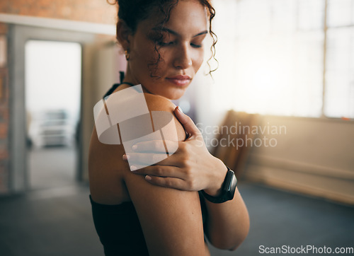 Image of Woman, fitness and shoulder injury from sports workout, exercise or training at the gym indoors. Female holding arm after painful sport accident, inflammation or bruise from intense exercising