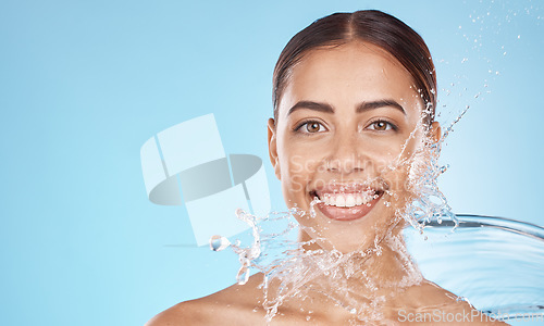 Image of Happy woman, face skincare or water splash on blue background studio in healthcare wellness, hygiene maintenance or grooming mockup. Smile portrait, beauty model and facial water drop in wet cleaning