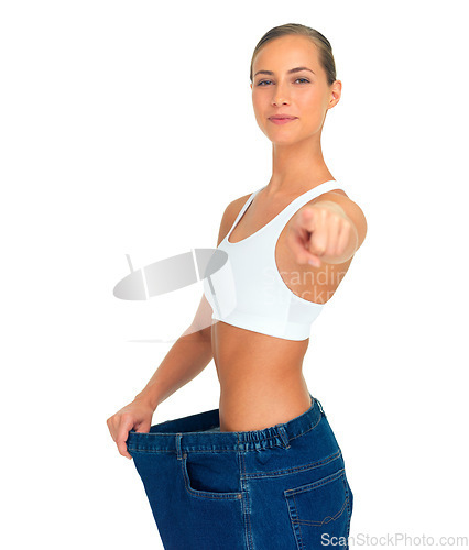 Image of Health, weight loss and woman pointing hand with jeans and tummy tuck with skinny waist, isolated on white background. Smile, healthcare and wellness, happy girl with liposuction, diet and big pants.