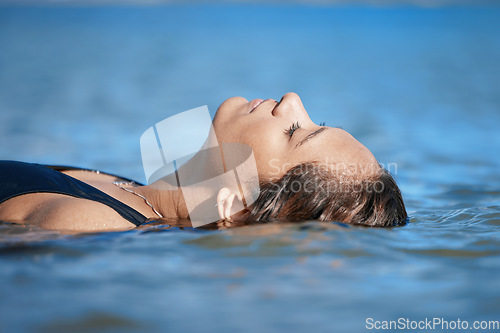 Image of Woman swimming, travel or fitness in ocean with peace, calm and exercise, wellness and waves at beach. Relax, female swimmer floating and sea with nature, freedom and water sport on summer vacation