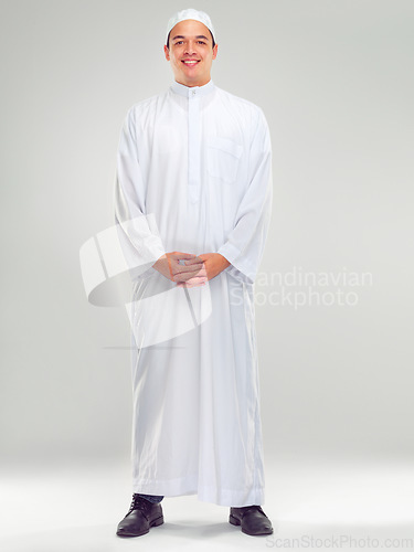 Image of Islamic man, religion fashion and standing for worship, prayer or spiritual happiness in white background. Arabic person, smile and happy respect for muslim culture or clothes isolated in studio