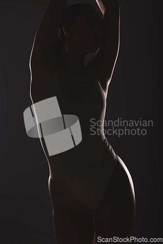 Image of Silhouette, beauty and woman in studio on dark background for cosmetics, wellness and sensual aesthetic. Creative art, fashion and torso of girl model pose for satisfaction, body care and figure