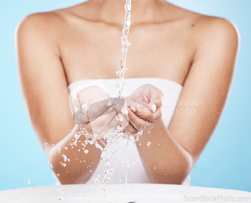 Image of Water splash, hands and skincare cleaning for beauty wellness, cosmetics skin dermatology and luxury hygiene in blue background studio. Model washing hand, shower water and clean body care routine