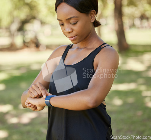 Image of Time, fitness or black woman in nature with a smartwatch to monitor heart health in training, exercise or park workout. Wellness, digital or girl runner checking running performance stats in Nigeria