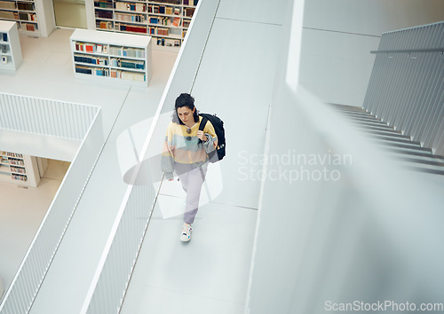 Image of Top view, woman and walking in library, college and education for knowledge, intelligence and smart. Female, student and girl with backpack, university and bookshelf for test, casual or trendy person
