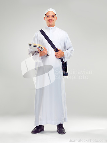 Image of Young muslim man, islamic clothes and standing for religious studying, worship or spiritual happiness in white background. Arabic student, happy and religion fashion or culture isolated in studio