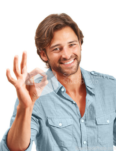 Image of Man with smile, Ok hand sign and agreement in portrait, good review with feedback and emoji against studio background. Yes gesture, success and vote with approval and male voice positive opinion