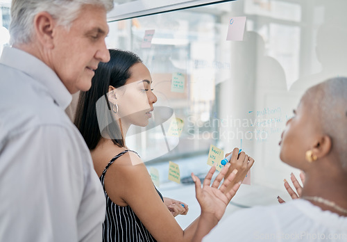 Image of Innovation, meeting or woman writing on a sticky note planning a startup project on glass board in office building. Focus, leadership or creative business people working on strategy ideas or solution