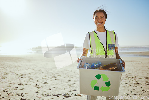Image of Recycle, plastic and woman cleaning beach for sustainability, green environment and eco friendly world with happy volunteering portrait. Box, bottle and black woman at sea for pollution or earth day