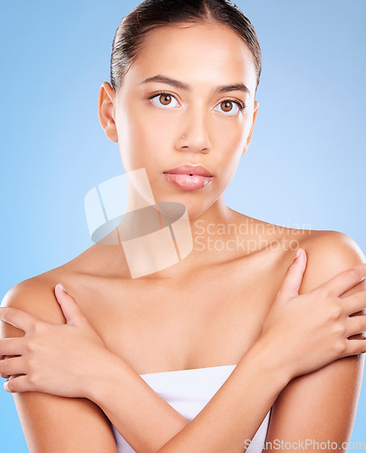 Image of Skincare, beauty and portrait of a woman in a studio for natural, self care and body care treatment. Health, wellness and girl model from Brazil with a facial routine isolated by a blue background.