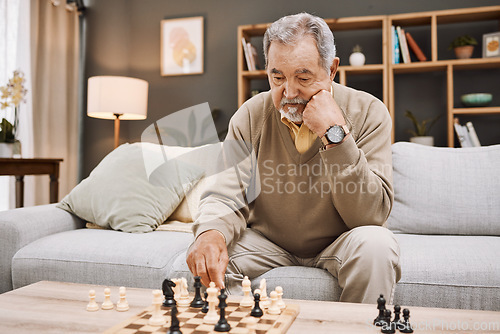 Image of Senior man, thinking or playing chess in house, home living room or apartment in Japanese strategy, checkmate or board game contest. Retirement elderly, smart person or chessboard challenge for mind