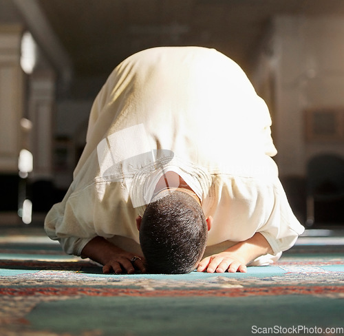 Image of Islam, religion and prayer of a muslim man at mosque in ramadan for spiritual faith, God and belief while doing religious worship. Islamic or Arab culture people sitting to pray at holy place