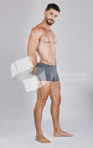 Image of Portrait, body and a man underwear model in studio on a gray background to promote a brand of drawers. Health, fitness and wellness with a handsome young male posing in underpants for comfort