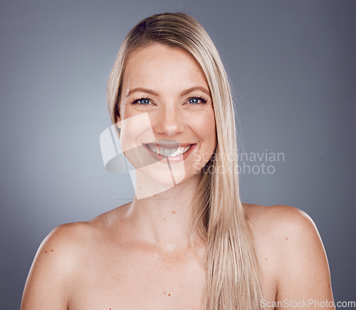 Image of Portrait, beauty and hair with a model woman in studio on a gray background for keratin treatment or natural haircare. Face, skincare and wellness with a female posing to promote a haircare product