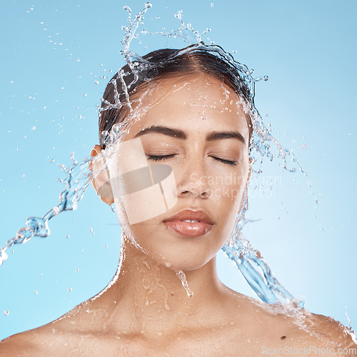 Image of Woman, washing face or water splash skincare on blue background studio in healthcare wellness, Brazil bathroom hygiene or self care grooming. Beauty model, water drop or facial cleaning in wet shower