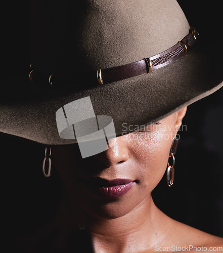 Image of Woman, dark studio and hat for fashion, beauty and mystery with style, design or closeup headshot. Girl, model and black background for fantasy, night aesthetic or makeup for edgy, sexy woman and art