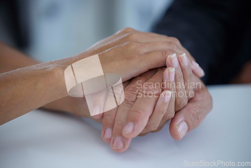 Image of Hands, care and love with a business woman consoling or comforting a man employee in the office at work. Help, console and hope with a female and male employee holding hands in comfort or support