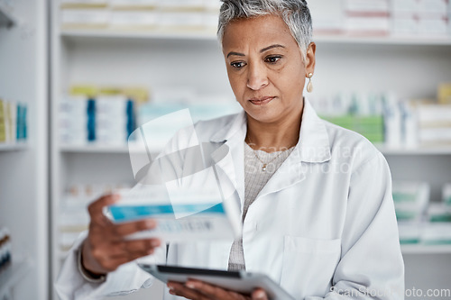 Image of Pharmacist woman, tablet and reading box for information, stock or wellness in store with focus. Senior pharma expert, digital tech and stock in pharmacy for medicine, health or online help in Mumbai