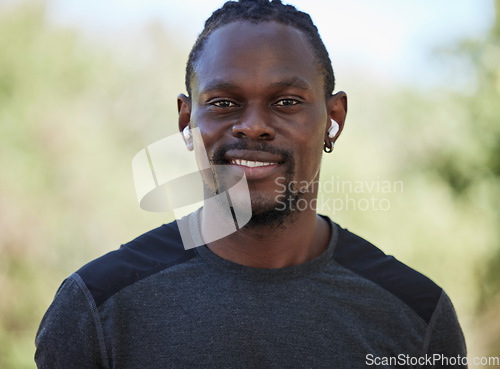 Image of Fitness, black man and portrait of happy runner, earphones and training exercise in Nigeria park. Face, smile and sports athlete listening to music for motivation, healthy goals and wellness workout