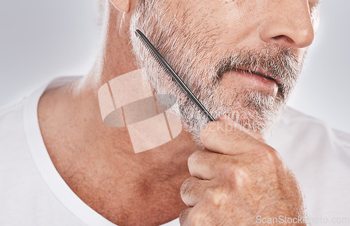 Image of Face, senior man and beard comb in studio isolated on a gray background. Skincare, facial hair care and elderly retired male model with product, tool or accessory for grooming, beauty and aesthetics.