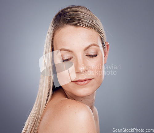 Image of Hair, beauty and skincare with a model woman in studio on a gray background with mockup for natural treatment. Haircare, keratin and face with an attractive young female posing to promote cosmetics