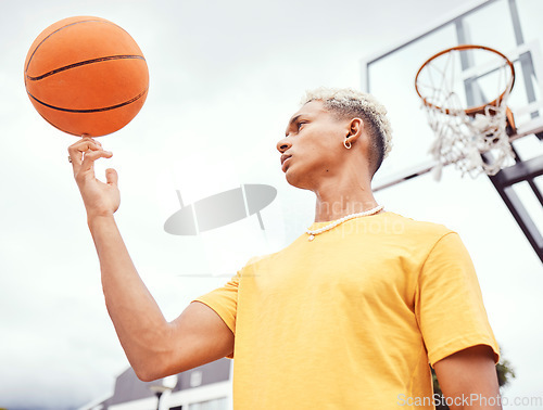 Image of Sports, fitness and man spinning basketball on court outdoors before workout, exercise or practice. Basketball court, balance and young male player with ball on finger getting ready for training.