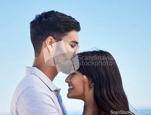 Image of Couple, forehead kiss and love outdoor with commitment, trust and happy together with bonding and care. Date, romance and relationship with young man, woman profile and smile against sky background