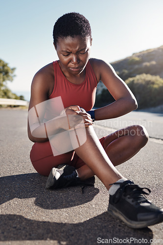 Image of Black woman, knee and sports injury on asphalt in pain from accident, exercise or run in the outdoors. African American woman suffering leg ache holding painful area, joint or bruise during workout