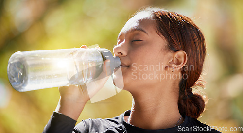 Image of Fitness, nature and woman drinking water after running for hydration, refresh and thirst. Sports, runner and female athlete enjoying a drink after cardio training for a race, marathon or competition.