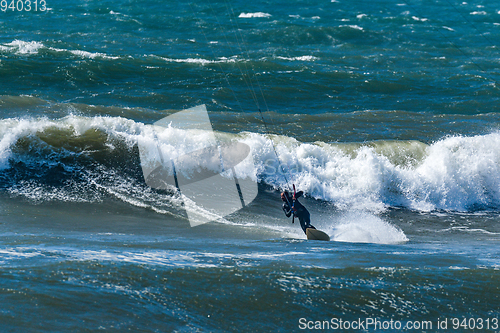 Image of Kitesurfer riding ocean waves