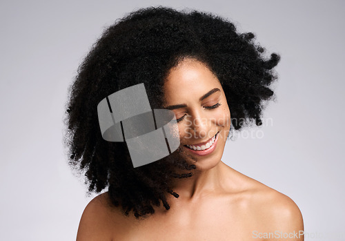 Image of Happy, natural and hair care shake of black woman satisfied with cosmetic treatment texture and volume. Self love, smile and happiness of african hair and skincare girl in gray studio background.