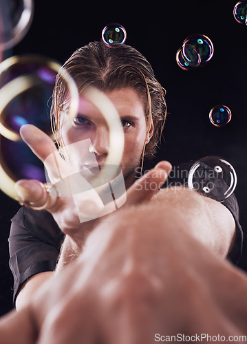 Image of Man hands, bubbles and magic portrait in studio for art performance, creative show and black background. Model focus, magician and soap with rainbow light, dark aesthetic or theater presentation