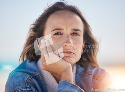 Image of Sad, thinking and depression with woman at beach feeling stress, exhausted and problems. Mental health, crisis and anxiety with face of girl alone with frustrated, worry and confused by the sea