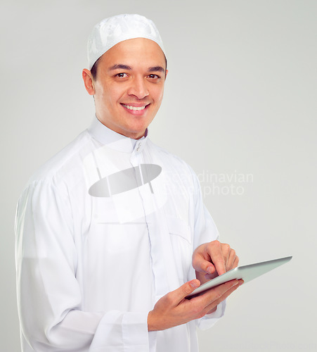 Image of Islamic man, tablet and happy portrait for Muslim reading, education or culture standing in white background. Young person, smile and digital tech learning for religious mindset isolated in studio