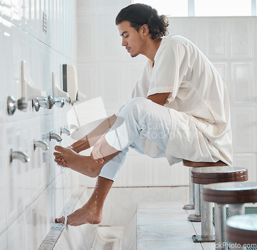 Image of Muslim, water and man cleaning feet for ablution, wudu or spiritual purification hygiene for Islamic religion, worship or moslem culture. Indonesia mosque, Islam faith and profile of man washing foot