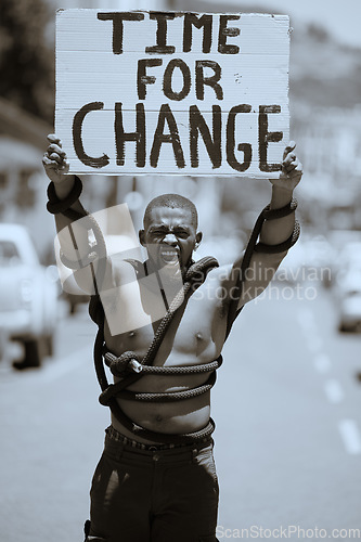 Image of Protest, city and portrait of a man with a poster against discrimination, racism or equality. Rope, sign and angry guy walking, protesting and shouting to fight for change, human rights or justice.