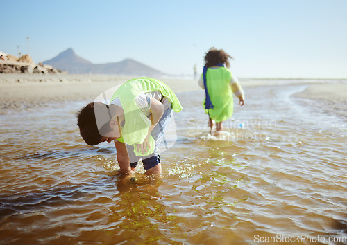 Image of Ocean, environment and young child cleaning for climate change and sustainability, environmental and volunteer for Earth day. Water pollution, nature and kids clean up beach and eco friendly activism