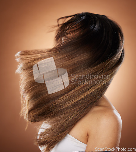 Image of Beauty, hair and salon with a model woman in studio on a brown background for keratin haircare treatment. Health, luxury and hair care with a young female posing to promote a natural hairstyle