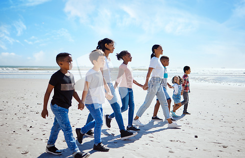 Image of Summer, children and friends walking on the beach, holding hands together for holiday or vacation. Nature, diversity and walk with a kids group bonding by the sea or ocean in the day for community