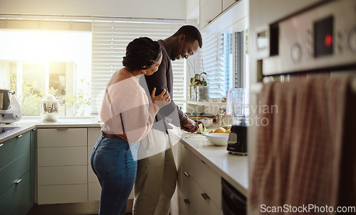 Image of Black couple, cooking and helping with food in kitchen at home while together to cook healthy food. Happy young man and woman in their house or apartment to bond and prepare lunch or dinner with love